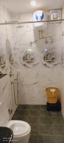 a bathroom with a toilet and a marble wall at Varanasi Villa(B&B) in Varanasi