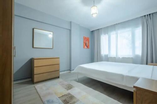 um quarto com uma grande cama branca e uma cómoda em A private room in the heart of Istanbul Sisli em Istambul