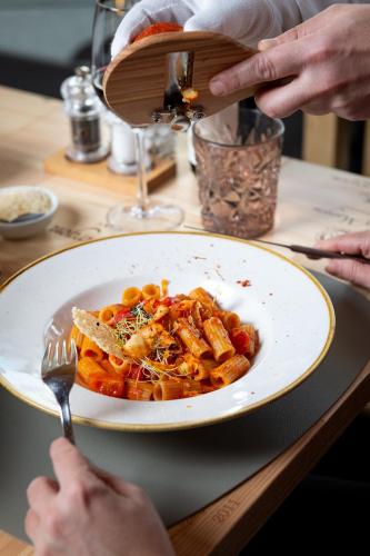 a person eating a plate of pasta on a table at Hostel by Randolins in St. Moritz