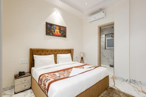 1 dormitorio con 1 cama grande y paredes blancas en Lime Tree B&B Pari Chowk, en Greater Noida