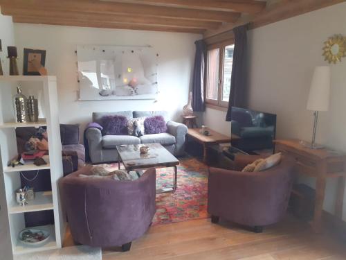 uma sala de estar com um sofá, uma mesa e cadeiras em Appartement La Suite Mont-Blanc em Chamonix-Mont-Blanc
