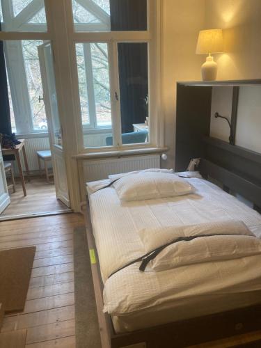 a large bed in a room with windows at Mini-Appartements am Burgberg in Bad Harzburg