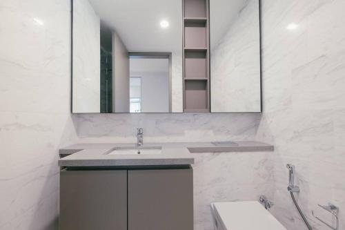 uma casa de banho branca com um lavatório e um espelho em NEW! Eaton Infinity SKY POOL KLCC view Pavilion em Kuala Lumpur