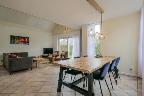 ein Wohnzimmer mit einem Holztisch und Stühlen in der Unterkunft Vakantiehuis Duyngroet - Landal park Ooghduyne Julianadorp aan Zee in Julianadorp