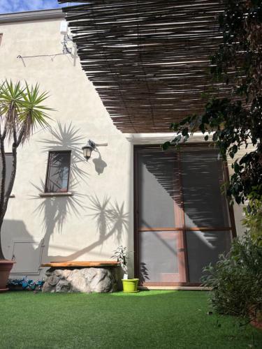 a white building with a door and a palm tree at Sardinia Costa Ovest in Càbras