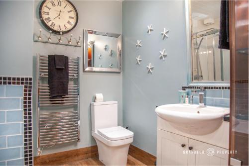 uma casa de banho com WC e um relógio na parede em 1 Bed LUX garden flat Central Bournemouth Parking - The Garden View Suite em Bournemouth