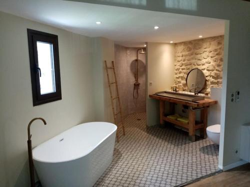 a bathroom with a tub and a sink and a toilet at Mas du Cuirassier- Vacances en Provence! in Châteaurenard