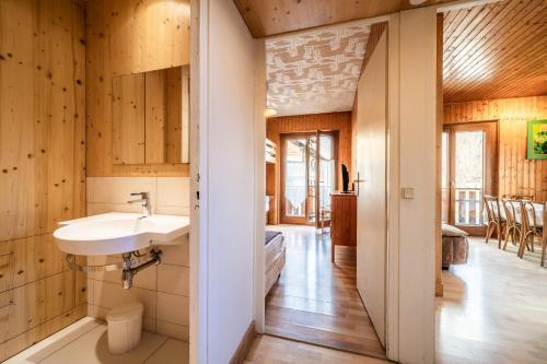 een badkamer met een wastafel en houten wanden bij Au soleil des coeurs - 6 pers in Morzine