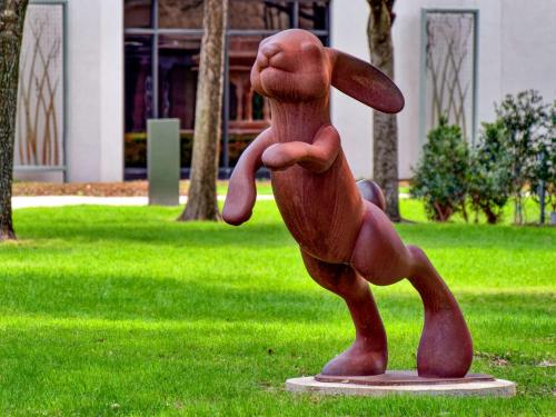 a statue of a person standing in the grass at Hilton Anatole in Dallas