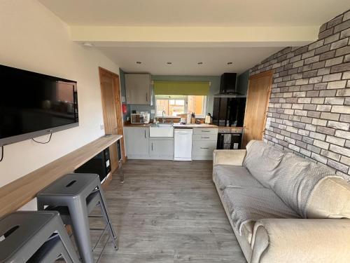 a living room with a couch and a brick wall at B3 Rickardos Holiday Lets in Mablethorpe