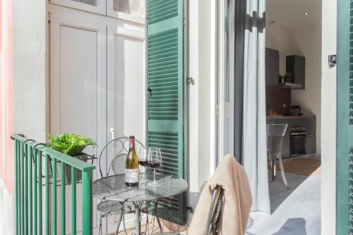 a table on a balcony with a bottle of wine at Cernobbio Dream Suites by Rent All Como in Cernobbio