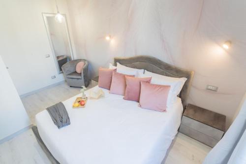 a bedroom with a white bed with pink pillows at Cernobbio Dream Suites by Rent All Como in Cernobbio