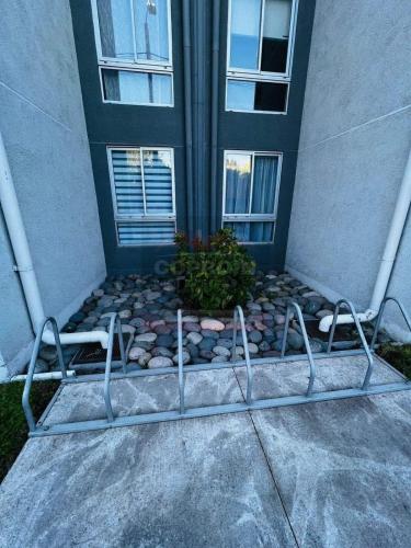 a metal bench in front of a building at Departamento Portal Tutuquen in Curicó