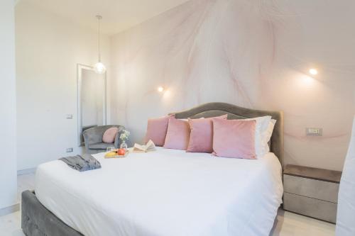 a bedroom with a large white bed with pink pillows at Cernobbio Dream Suites by Rent All Como in Cernobbio