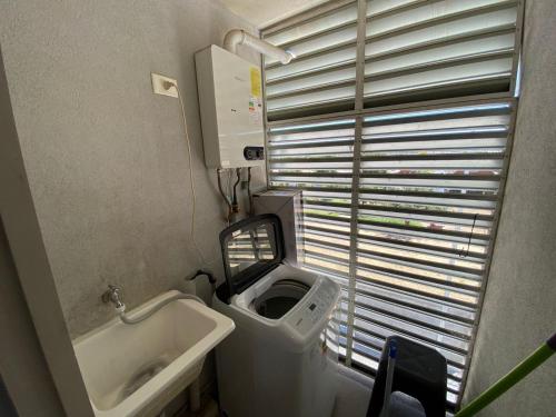 a small bathroom with a sink and a toilet at Departamento Portal Tutuquen in Curicó