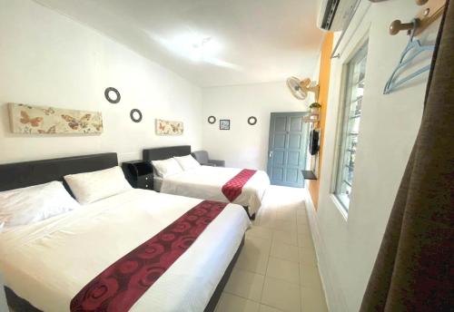 a hotel room with two beds and a window at OYO 90935 Langkawi Western Motel in Pantai Cenang