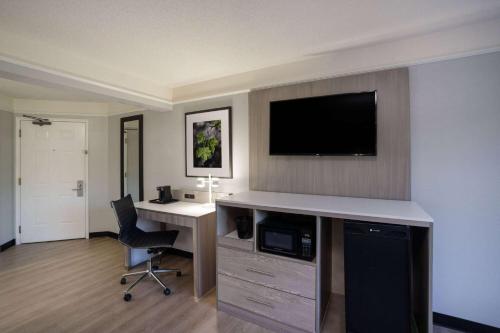 a hotel room with a desk and a flat screen tv at La Quinta by Wyndham Birmingham Hoover in Hoover