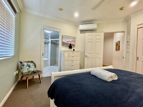 a bedroom with a bed and a chair and a window at Townsville Beachfron Apartments on the Strand - 2 in Townsville