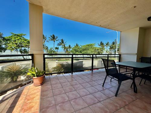 a patio with a table and chairs on a balcony at Townsville Beachfront Apartment on the Strand - 2 in Townsville