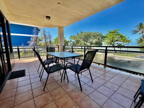a patio with a table and chairs on a balcony at Townsville Beachfront Apartment on the Strand - 2 in Townsville