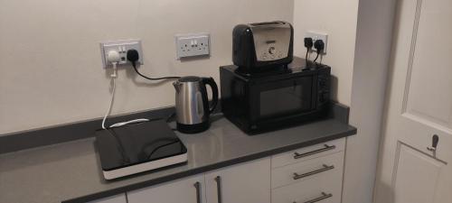a kitchen counter with a microwave and a television at Private annex to Victorian villa, with kitchen and Free parking in Todmorden