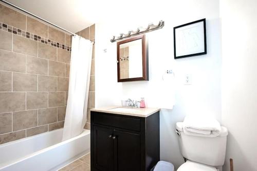 a bathroom with a toilet and a sink and a tub at The Terrace at Park Place 2nd floor walk up -cozy 2 bedroom fast WiFi free coffee in Wilmington