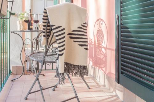 a blanket on a chair on a balcony at Cernobbio Dream Suites by Rent All Como in Cernobbio