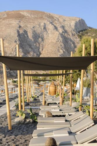 a row of white lounges on the beach at Afroditi Venus Beach Resort in Kamari