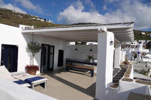 a patio with a wooden bench on a white building at The Artist House in Triandáros