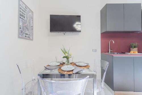 a kitchen with a table with chairs and a sink at Cernobbio Dream Suites by Rent All Como in Cernobbio