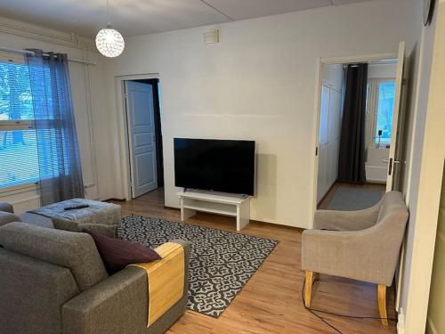 a living room with a couch and a flat screen tv at ”Paris” -2BR with sauna&balcony in Tornio