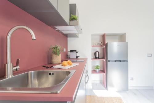 a kitchen with a sink and a refrigerator at Cernobbio Dream Suites by Rent All Como in Cernobbio