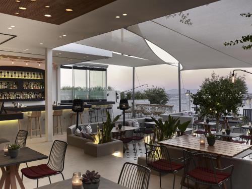 a restaurant with tables and chairs and a bar at Afroditi Venus Beach Resort in Kamari