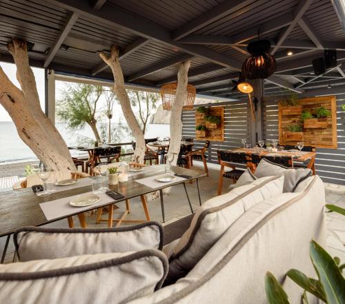 a restaurant with couches and tables and chairs at Afroditi Venus Beach Resort in Kamari