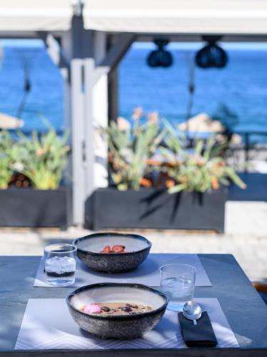 a table with two bowls of food and two glasses at Afroditi Venus Beach Resort in Kamari