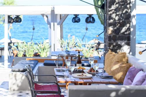a table with plates of food and glasses on a patio at Afroditi Venus Beach Resort in Kamari