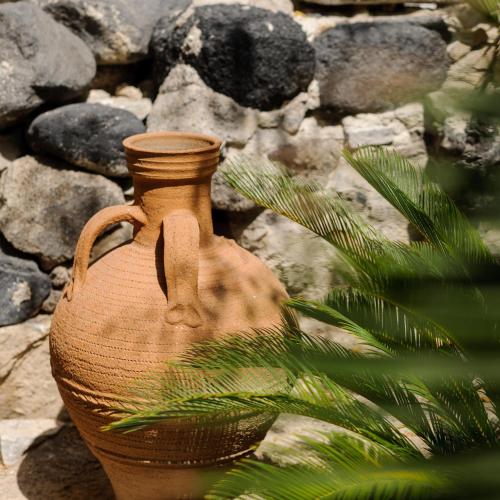 a brown vase sitting next to a pile of rocks at Afroditi Venus Beach Resort in Kamari