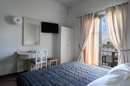 a bedroom with a bed and a sink and a window at Afroditi Venus Beach Resort in Kamari