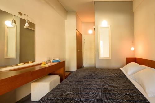 a bedroom with a bed and a sink and a mirror at Afroditi Venus Beach Resort in Kamari