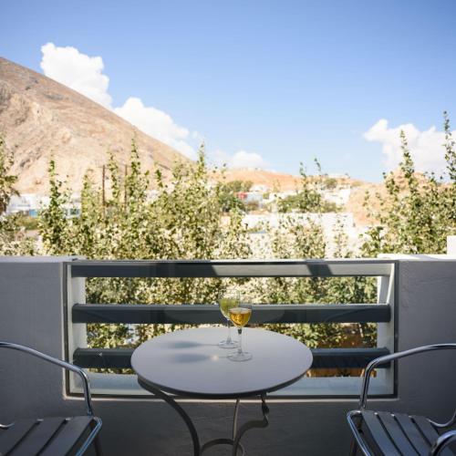 a table with a glass of wine on a balcony at Afroditi Venus Beach Resort in Kamari