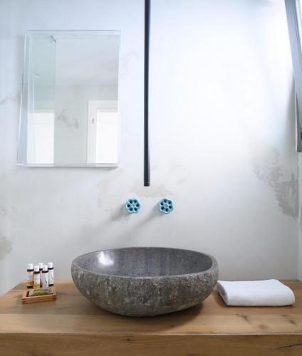 a bathroom with a large stone sink on a wooden counter at Afroditi Venus Beach Resort in Kamari