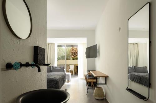 a living room with a bed and a mirror at Afroditi Venus Beach Resort in Kamari