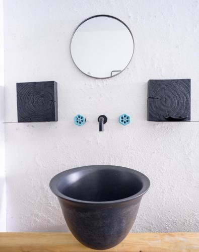 a black bowl on a table with a mirror at Afroditi Venus Beach Resort in Kamari