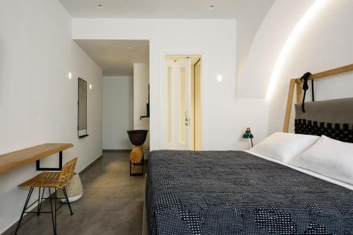 a bedroom with a large bed and a desk at Afroditi Venus Beach Resort in Kamari