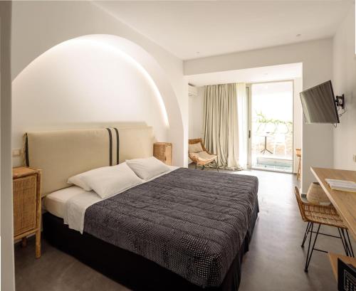 a bedroom with a bed and a large window at Afroditi Venus Beach Resort in Kamari