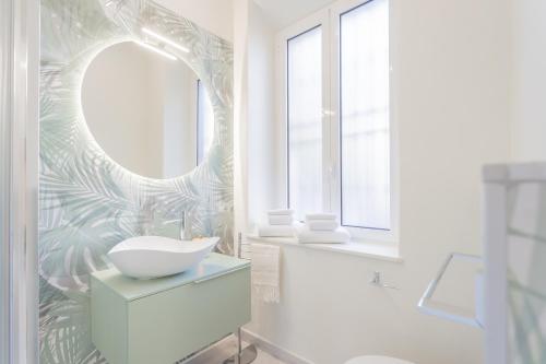a bathroom with a white sink and a mirror at Cernobbio Dream Suites by Rent All Como in Cernobbio
