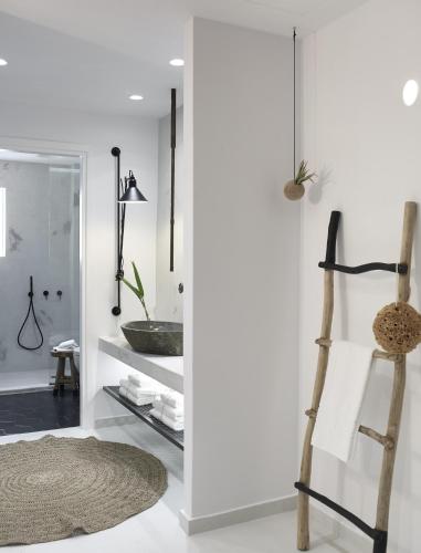 a bathroom with white walls and a wooden ladder at Afroditi Venus Beach Resort in Kamari