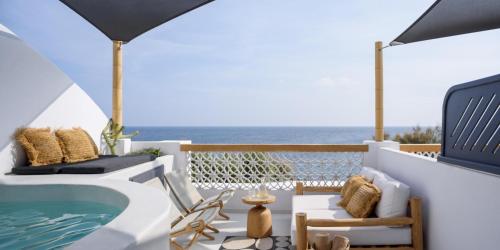a patio with a hot tub and the ocean at Afroditi Venus Beach Resort in Kamari