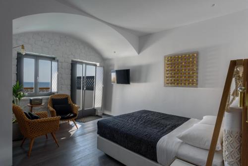 a bedroom with a bed and a desk and chairs at Afroditi Venus Beach Resort in Kamari