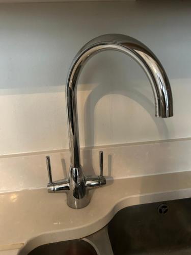 a kitchen sink with a silver faucet at Modern Apartment in Holland Park in London